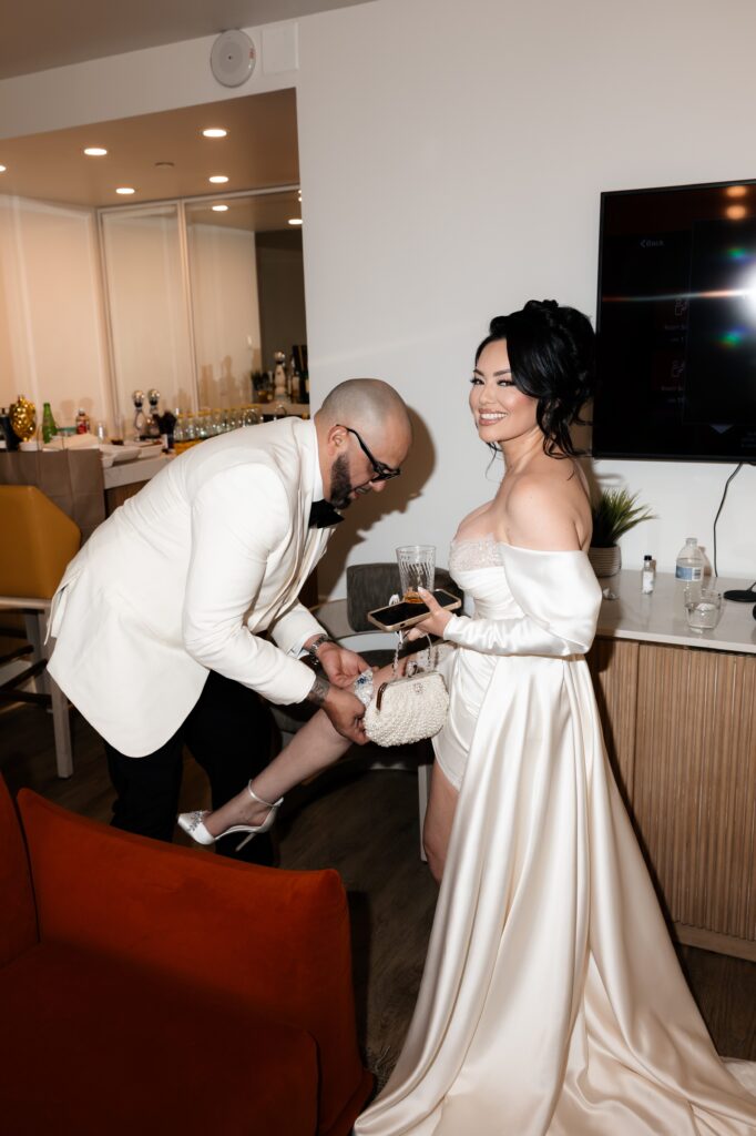 Groom helping his bride with her heels at Virgin Hotel Las Vegas