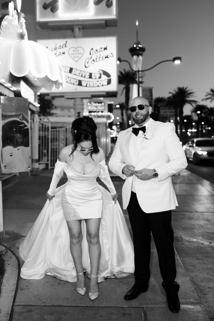 Black and white photo of a bride and groom posing at The Little White Wedding Chapel for their Las Vegas elopement photos. 