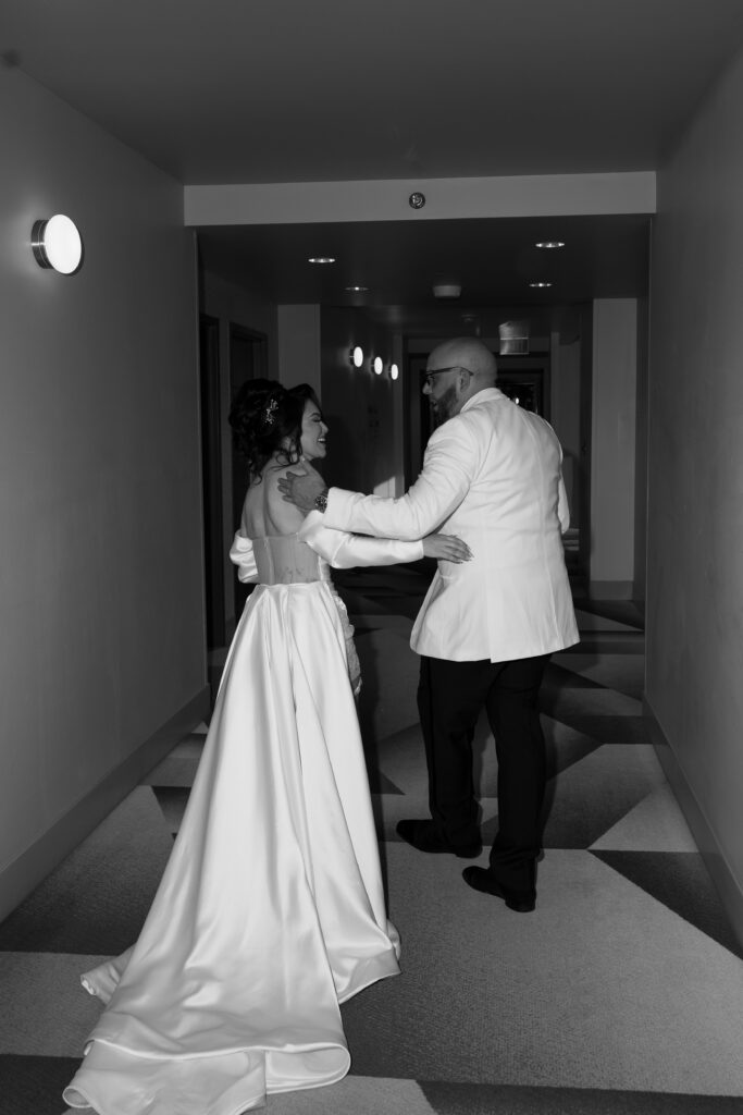 Black and white photo of a bride and groom walking down the hallway at Virgin Hotel in Las Vegas