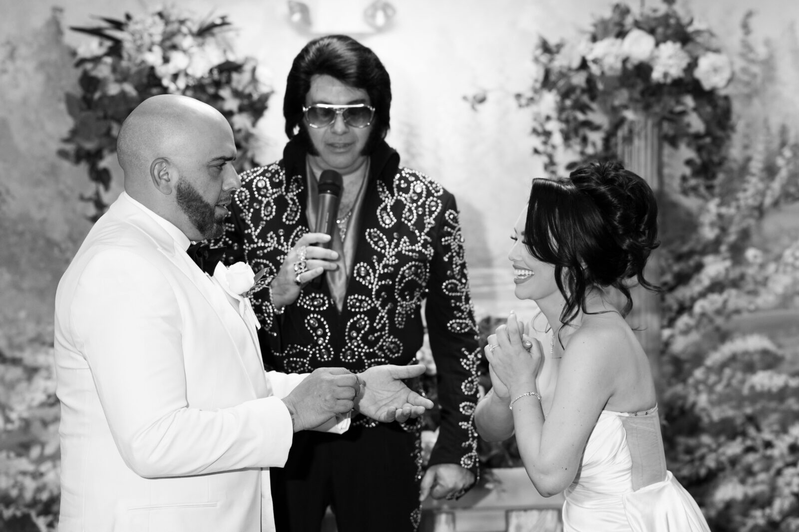 Black and white photo of a bride and groom during their Elvis wedding ceremony in Chapel Amore at The Little White Wedding Chapel