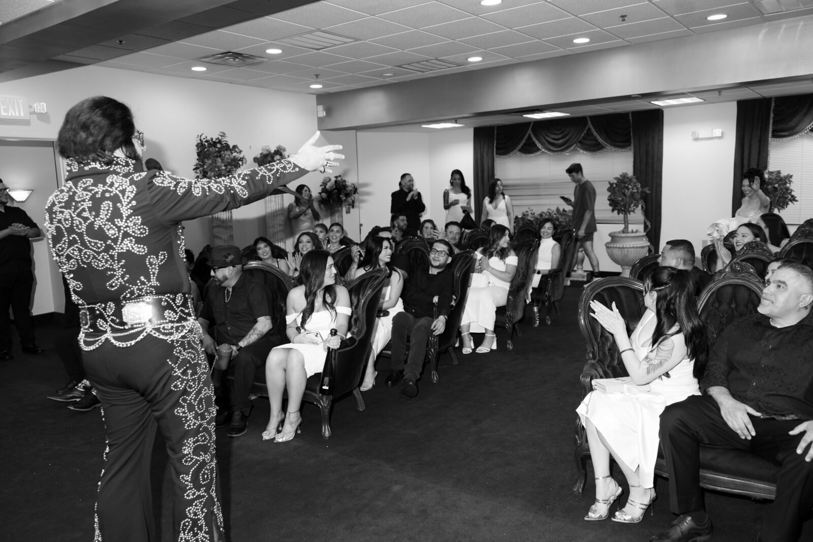 Black and white photo of Elvis singing to the bride, groom and their wedding guests