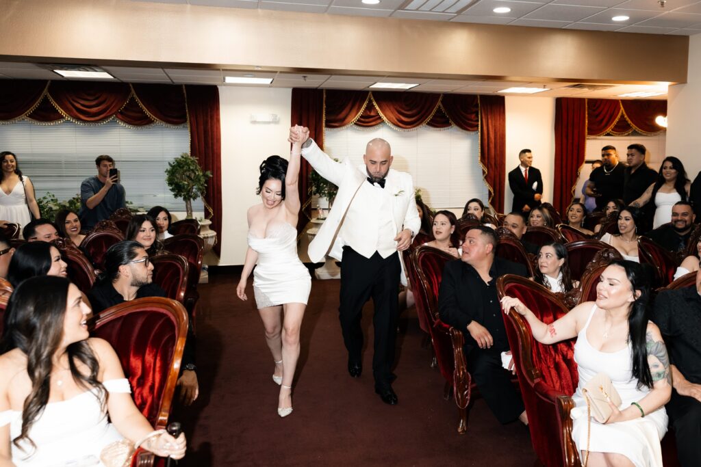 Bride and groom holding hands and walking down the aisle