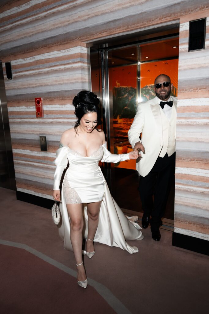 Flash paparazzi shot of a bride and groom getting of Virgin Hotel elevator for their Las Vegas elopement 