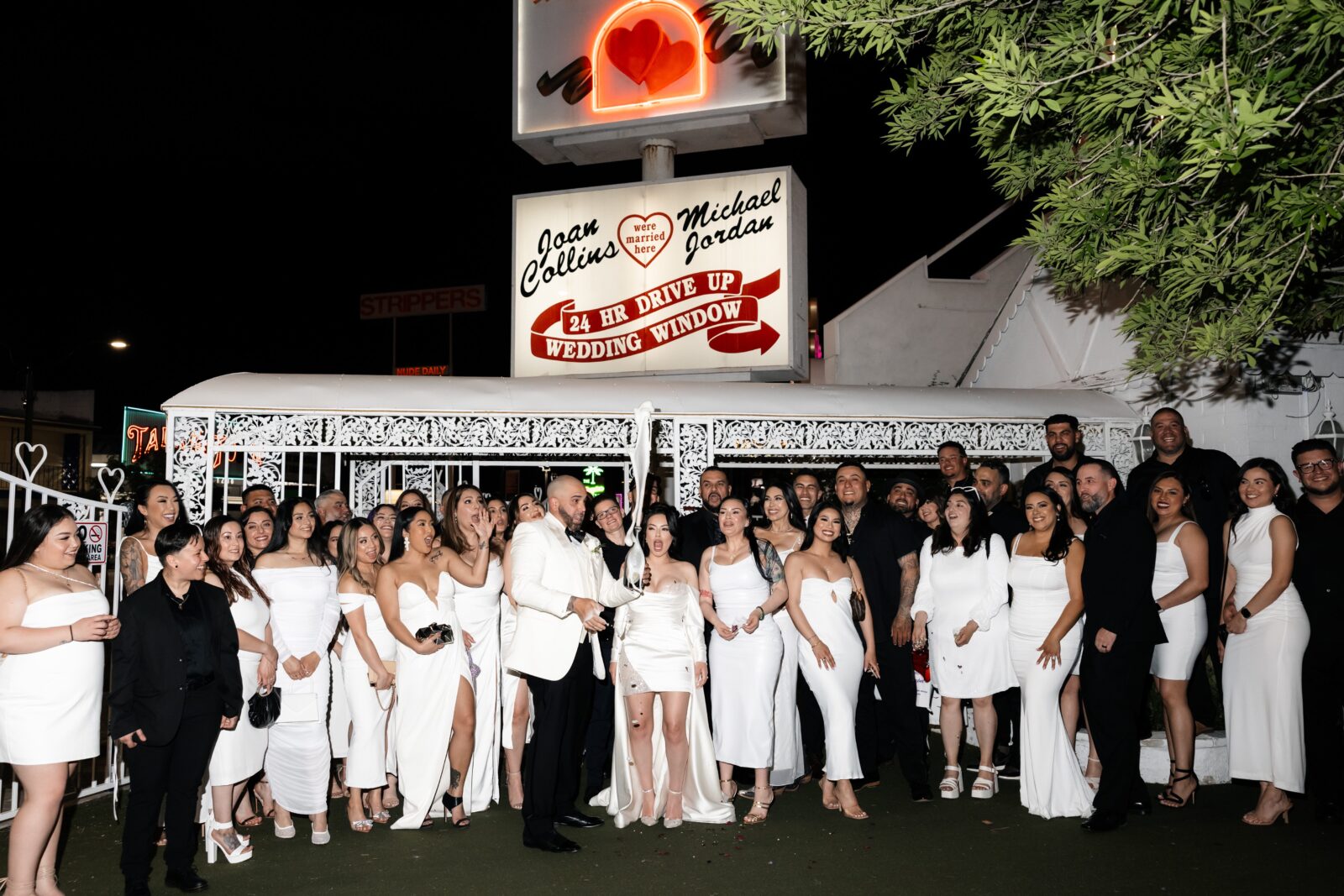 Bride and groom popping champagne at The Little White Wedding Chapel