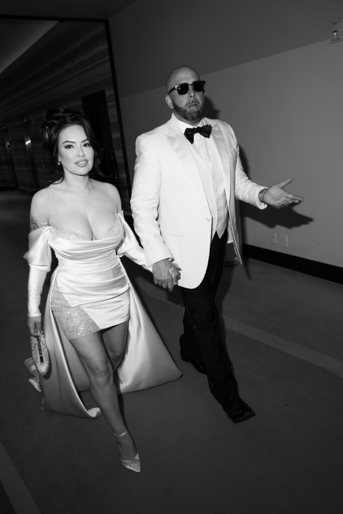 Black and white flash elopement photo of a bride and groom walking during their Las Vegas elopement