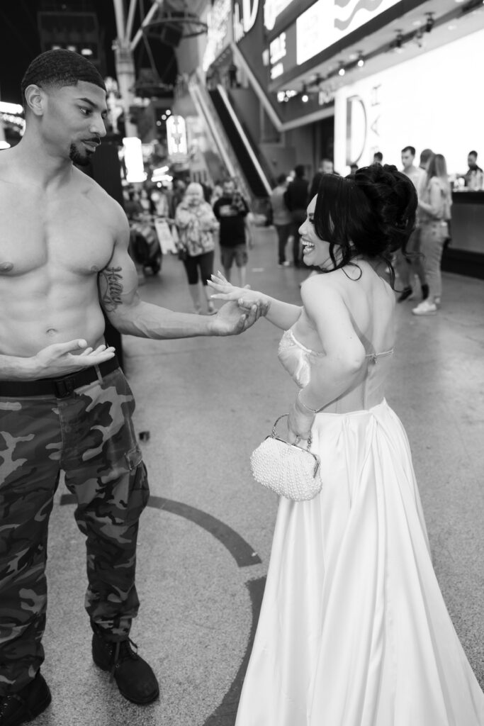 Bride saying hi to a shirtless man on the Las Vegas strip during her downtown Vegas elopement