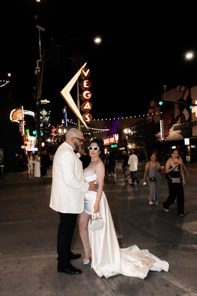 Bride and grooms sexy downtown Vegas elopement portraits in front of the neon Vegas sign. 