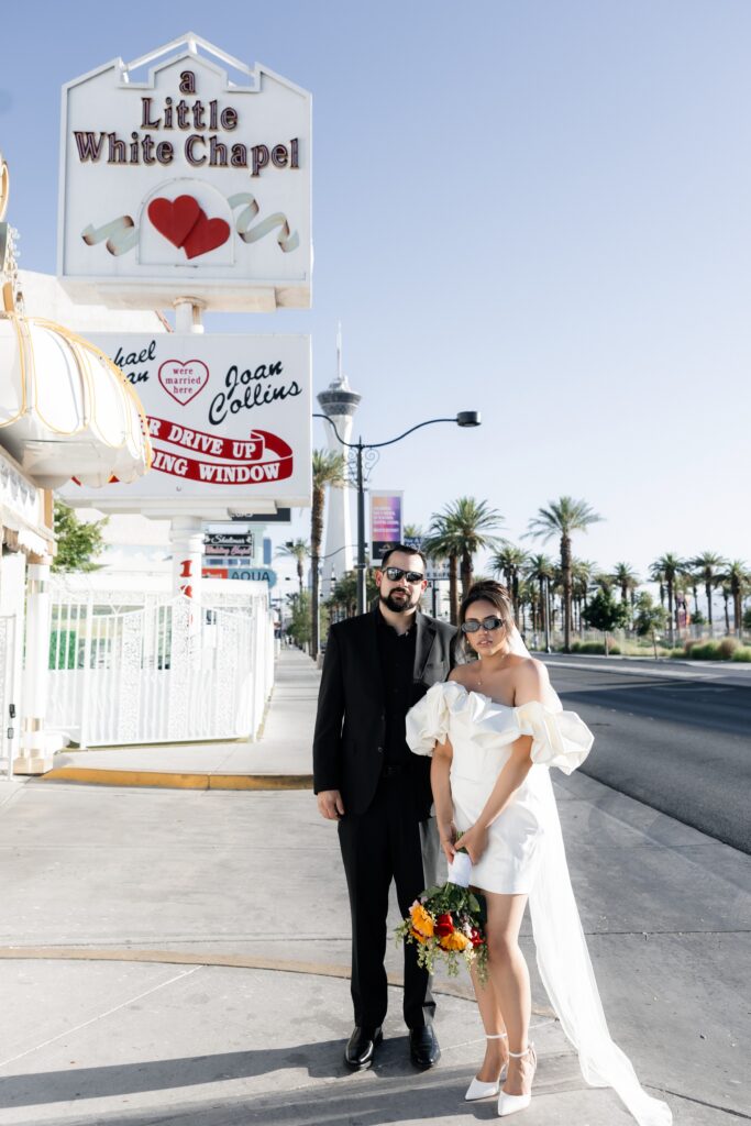 Bride and grooms portraits in front of a Little White Chapel sign in Las Vegas