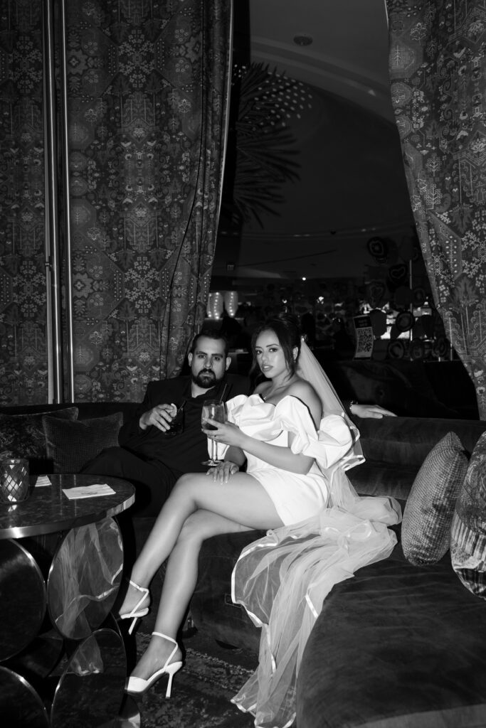 Black and white photo of a bride and groom drinking cocktails