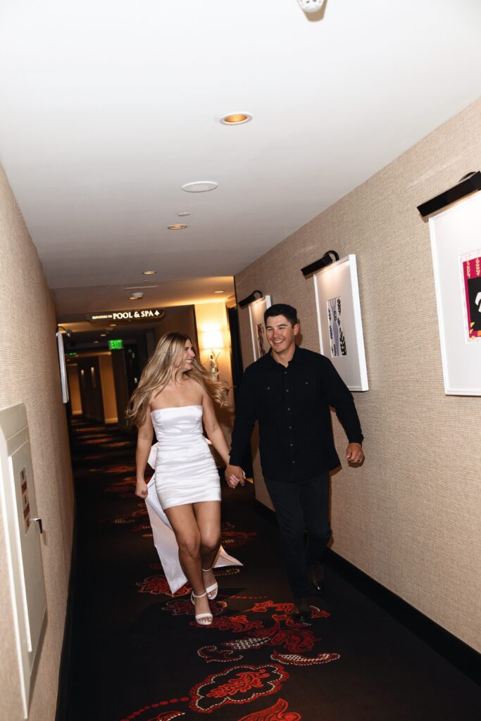 Bride and groom running down the hallway for their fun Encore Las Vegas wedding portraits