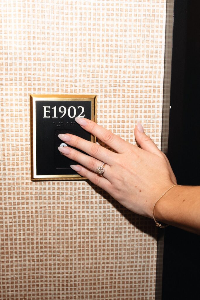 Close up shot of a bride putting her hand on a room number