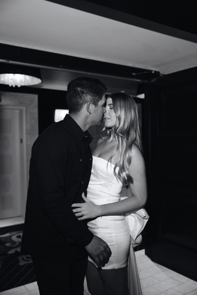 Black and white photo of a bride and groom kissing during their sexy Encore Las Vegas wedding portraits