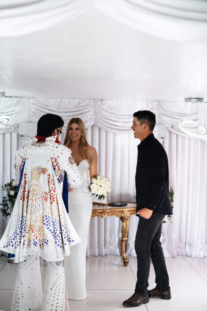 Bride and groom talking to the Elvis impersonator after their Little White Chapel elopement