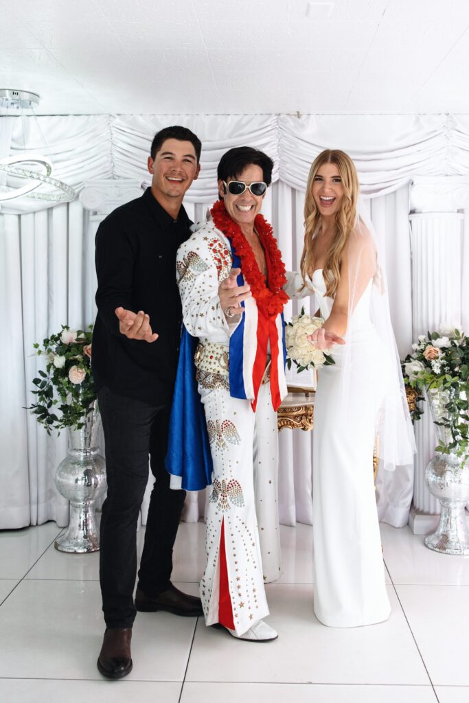 Bride and groom posing with the Elvis impersonator for their Little White Chapel elopement in Las Vegas