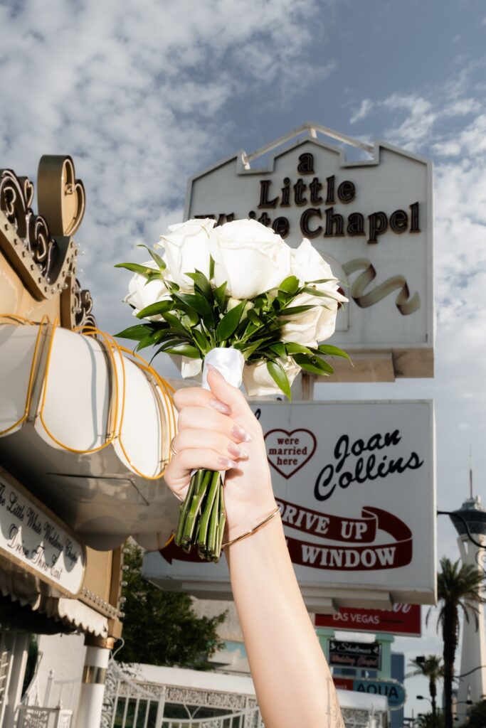 Flash photo of a bride holding up her Little White Wedding Chapel flowers