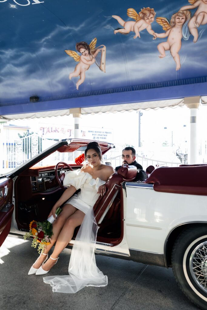 Bride and groom posing inside The Risky Ride for their Little White Wedding Chapel elopement