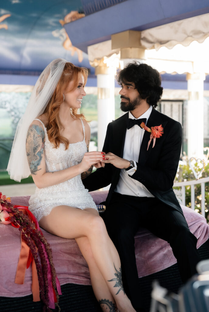 Couple exchanging rings during their Pink Cadillac wedding ceremony.