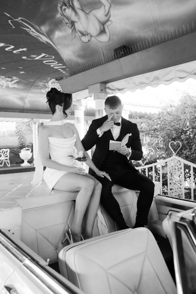 Black and white photo of a groom getting emotional as he reads his vows to the bride during their Pink Cadillac wedding ceremony.