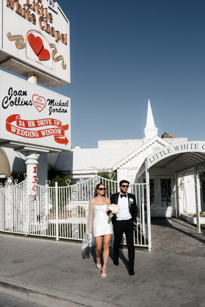 Bride and groom walking outside of The Little White Wedding Chapel in Las Vegas.