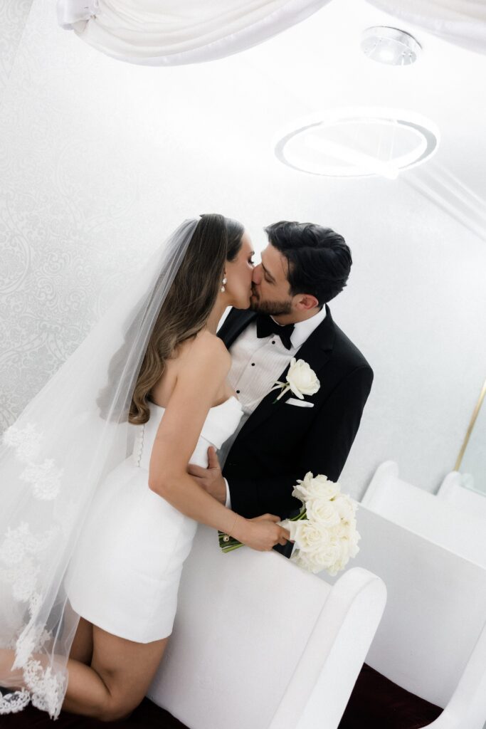 Bride and groom kissing in the original Little White Wedding Chapel in Las Vegas.