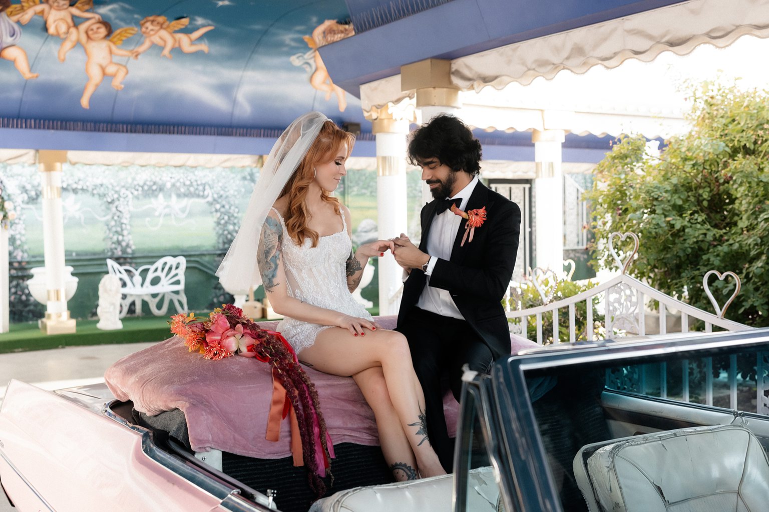 Bride and groom exchanging rings during their Pink Cadillac wedding ceremony in The Tunnel of Love.