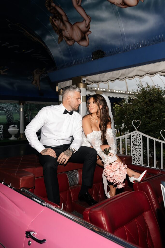 Bride and groom posing in the Pink Cadillac in The Tunnel of Love.