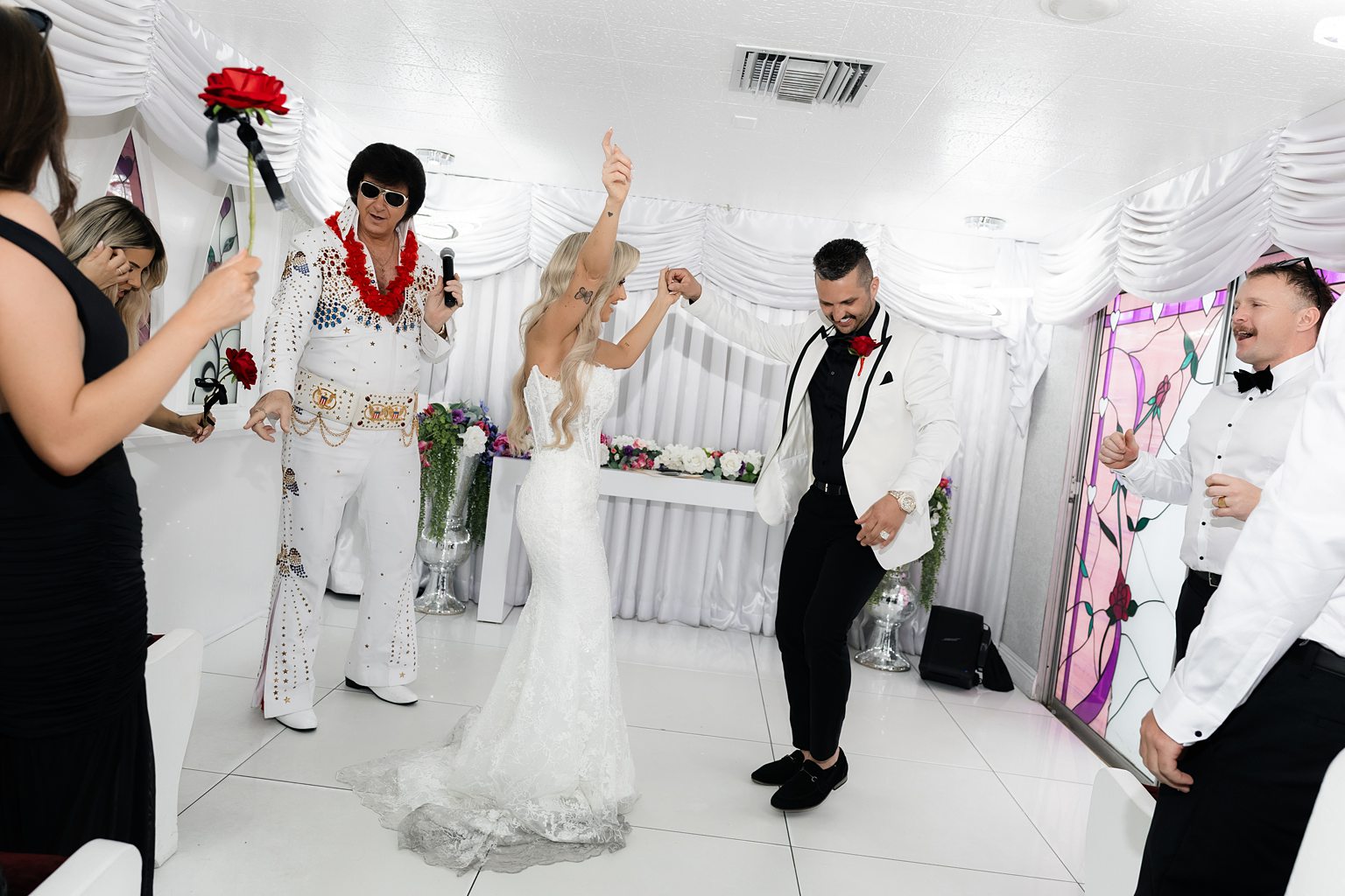 Bride and groom dancing with their Elvis officiant during their Little White Wedding Chapel ceremony.