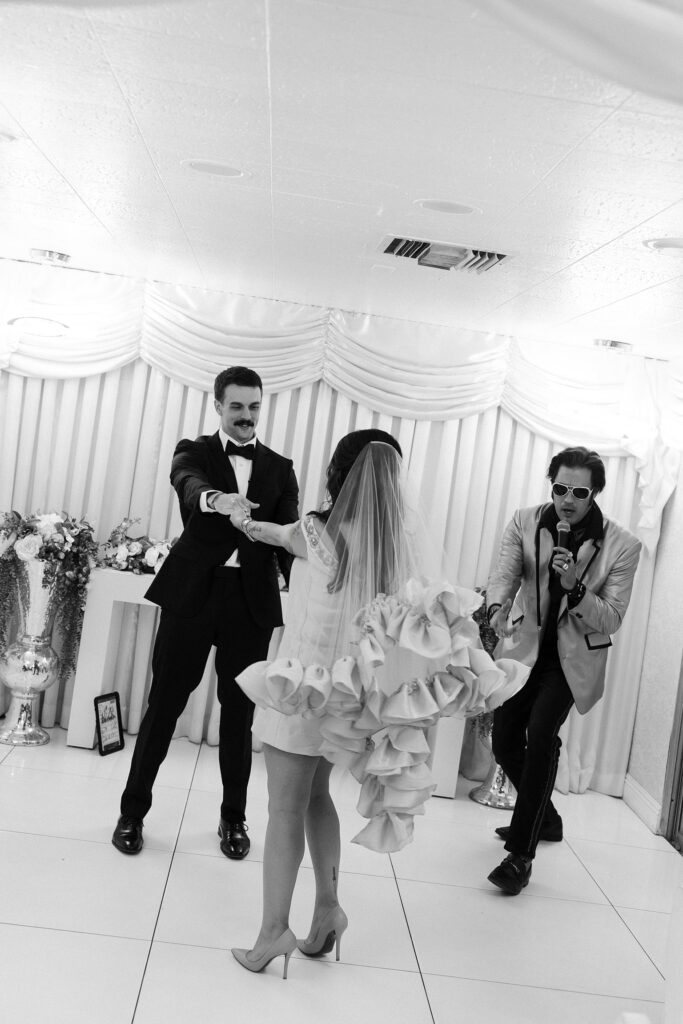 Bride and groom dancing with their Elvis officiant during their Little White Chapel wedding ceremony.