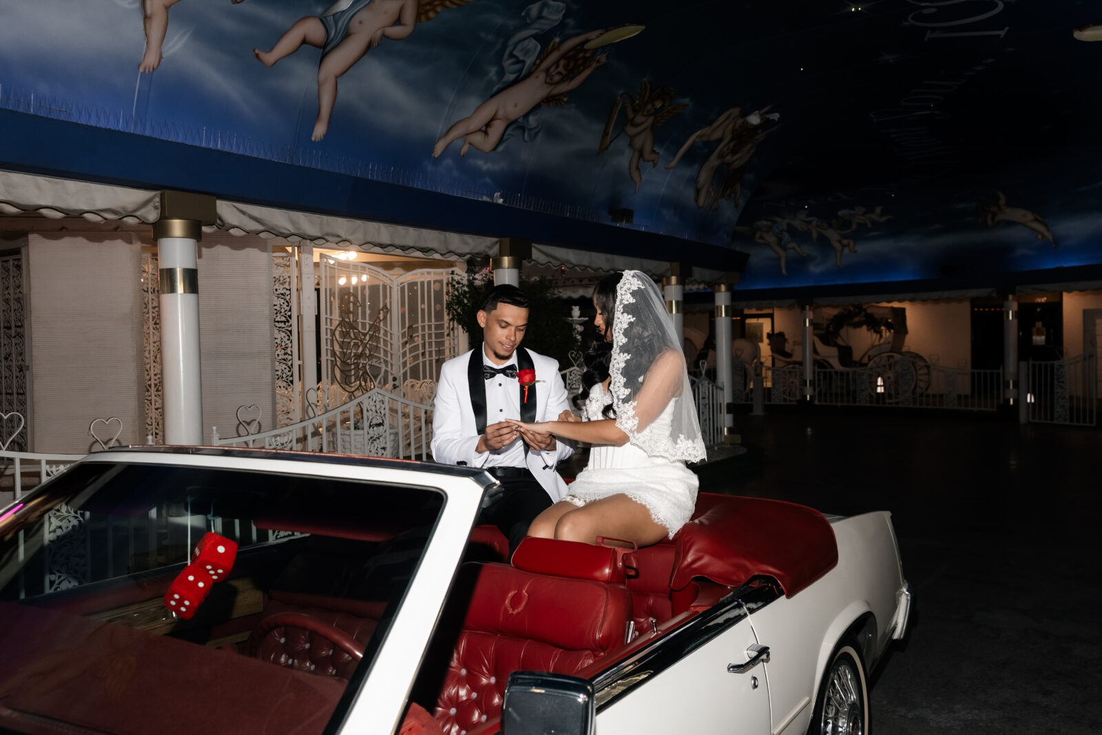 Bride and groom exchanging rings while in the Risky Ride for their Tunnel of Love Drive-Thru Ceremony at The Little White Wedding Chapel.