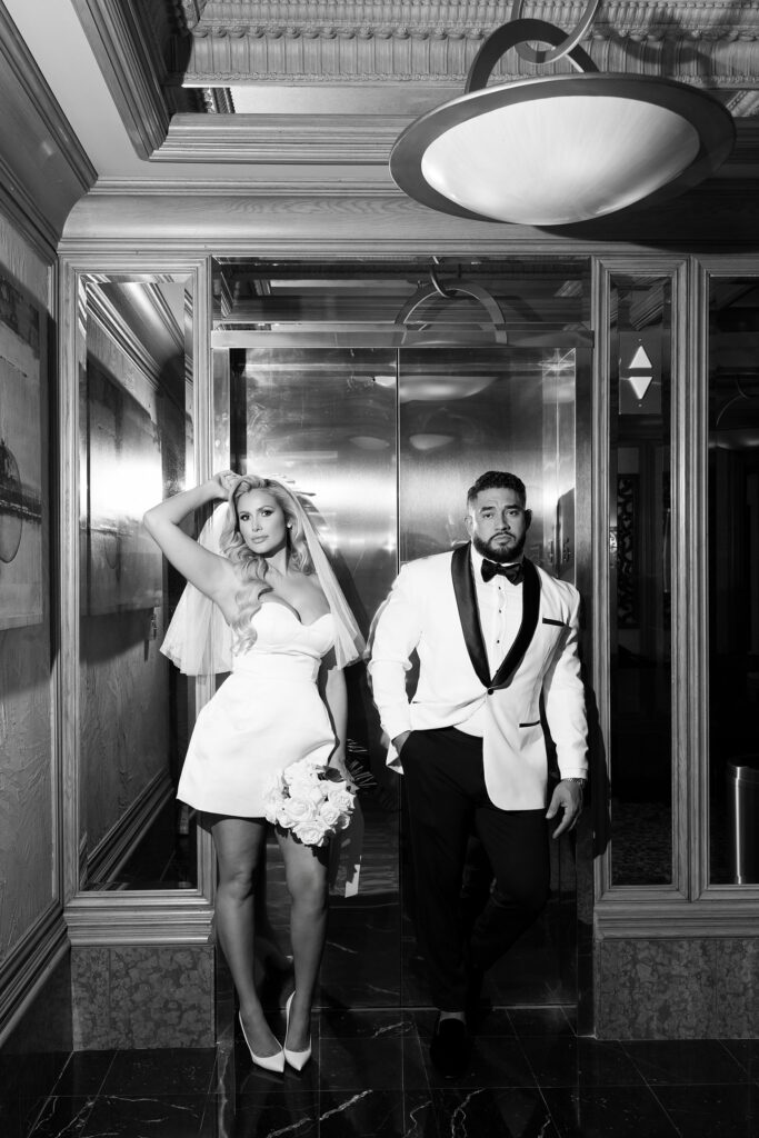 Black and white photo of a bride and groom posing by the elevator at Golden Nugget in Las Vegas