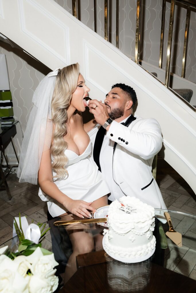 Groom feeding the bride a piece of their heart shaped elopement cake