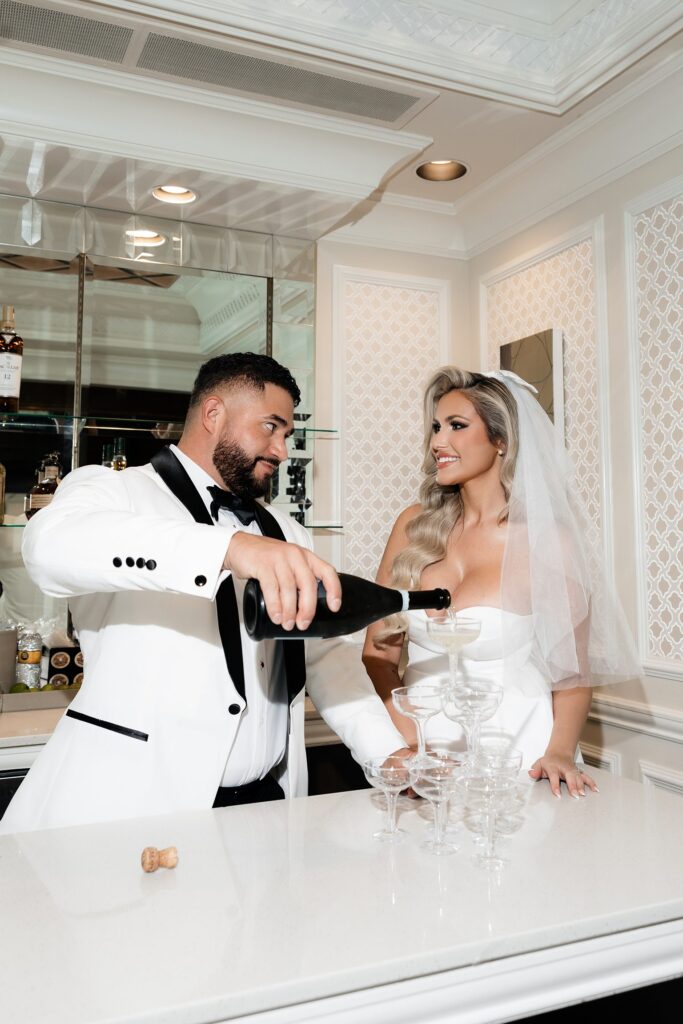 Bride and groom pouring a champagne tower during their Las Vegas elopement at Golden Nugget