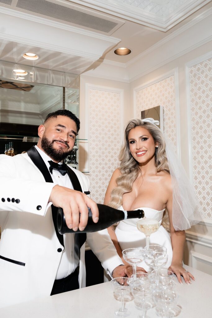 Bride and groom pouring a champagne tower during their Las Vegas elopement at Golden Nugget