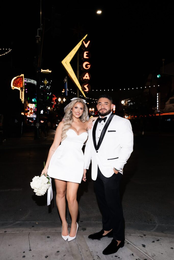 Bride and groom posing for portraits on Fremont Street in Las Vegas at night