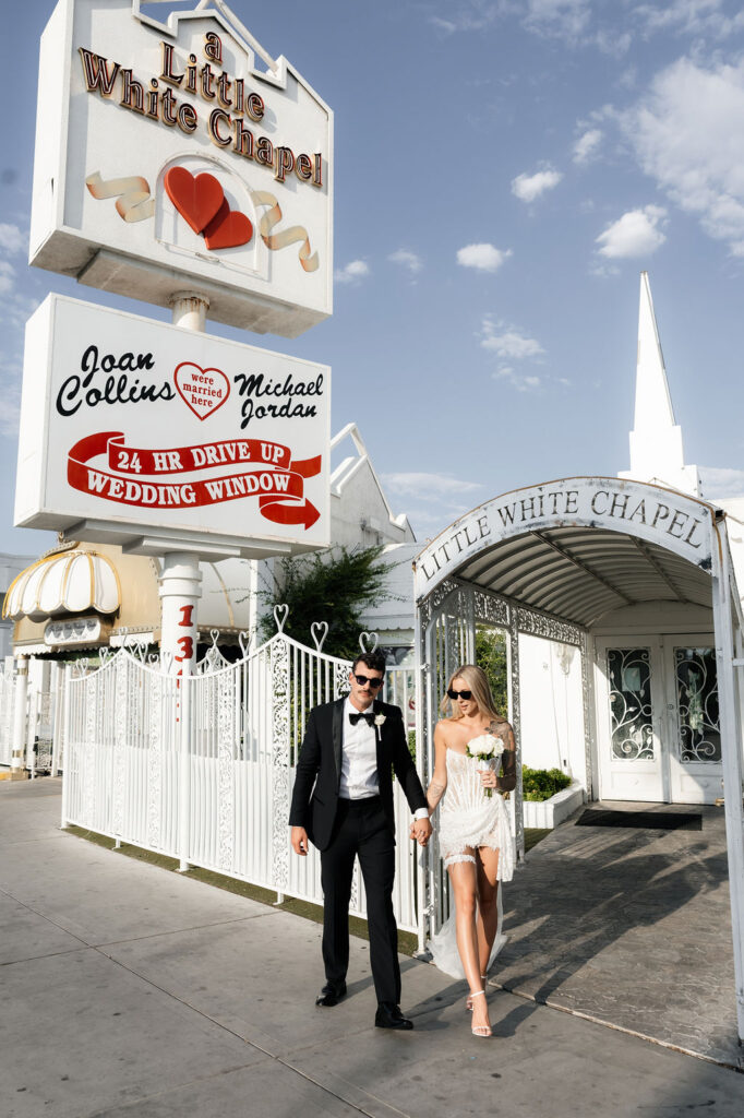 Bride and groom posing in front of The Little White Wedding Chapel in Las Vegas