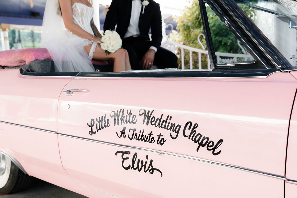 Bride and groom posing in the Pink Cadillac at The Little White Wedding Chapel in Las Vegas