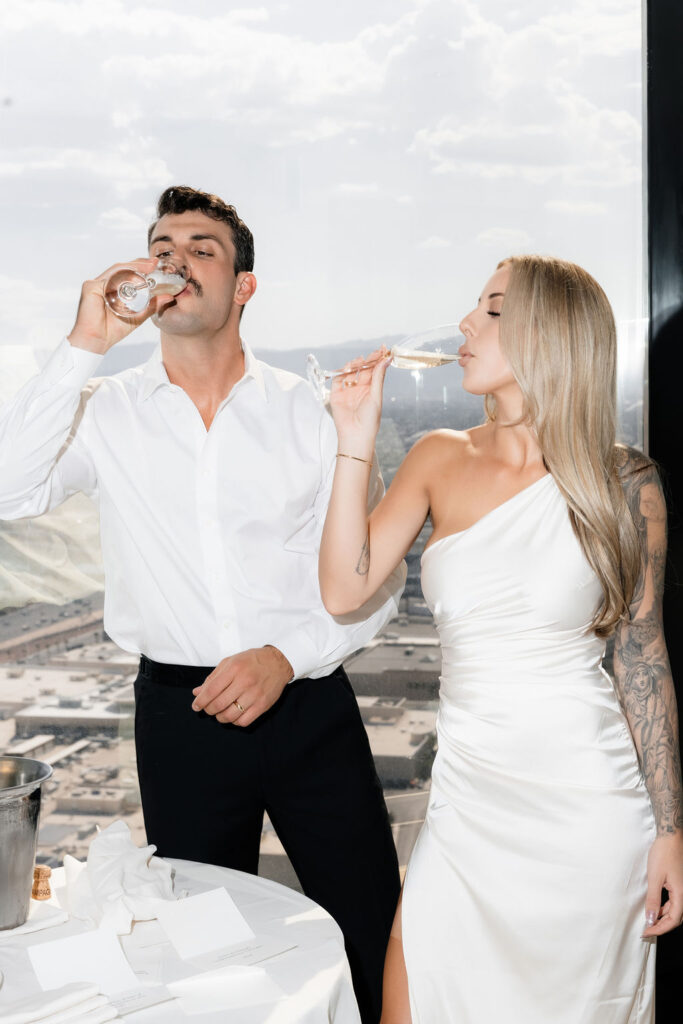 Bride and groom drinking champagne during their Las Vegas hotel elopement