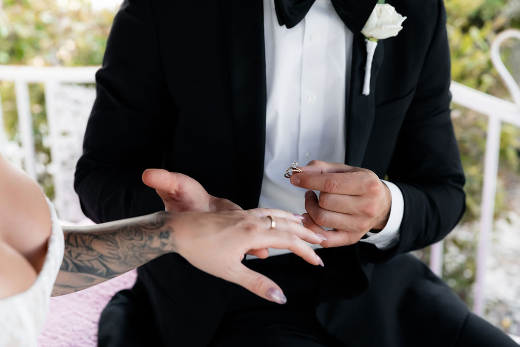 Groom putting a ring on the brides finger