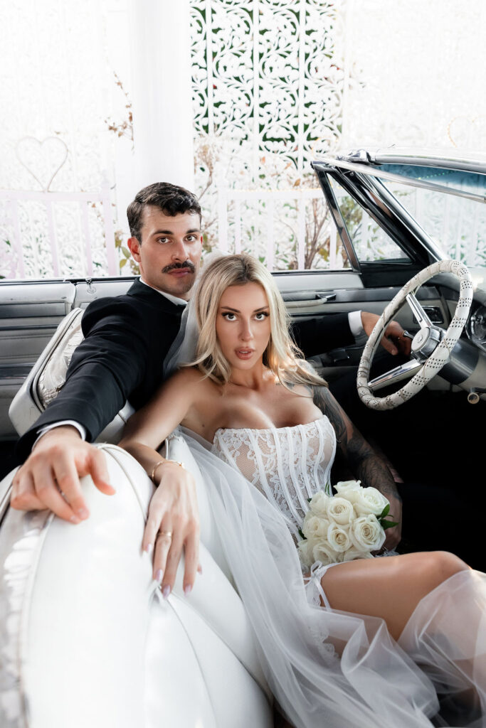 Bride and grooms editorial portraits in the Pink Cadillac at The Little White Wedding Chapel