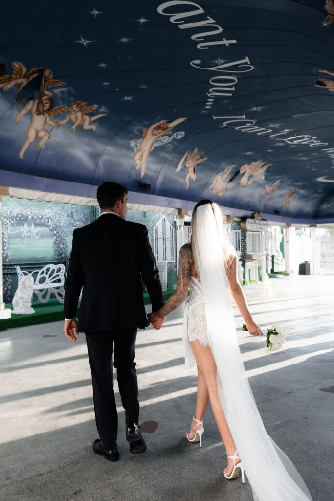 Bride and groom walking in The Tunnel of Love at The Little White Wedding Chapel