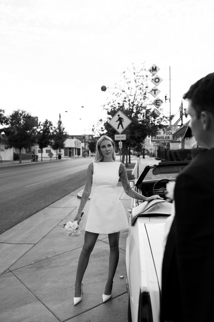 Bride and groom posing with a classic car for their elopement photos