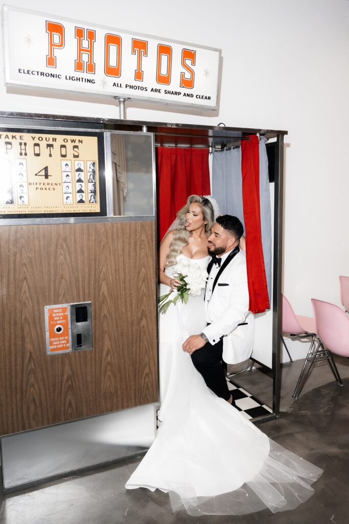 Bride and groom taking pictures in the vintage photo booth at Sure Thing Wedding Chapel