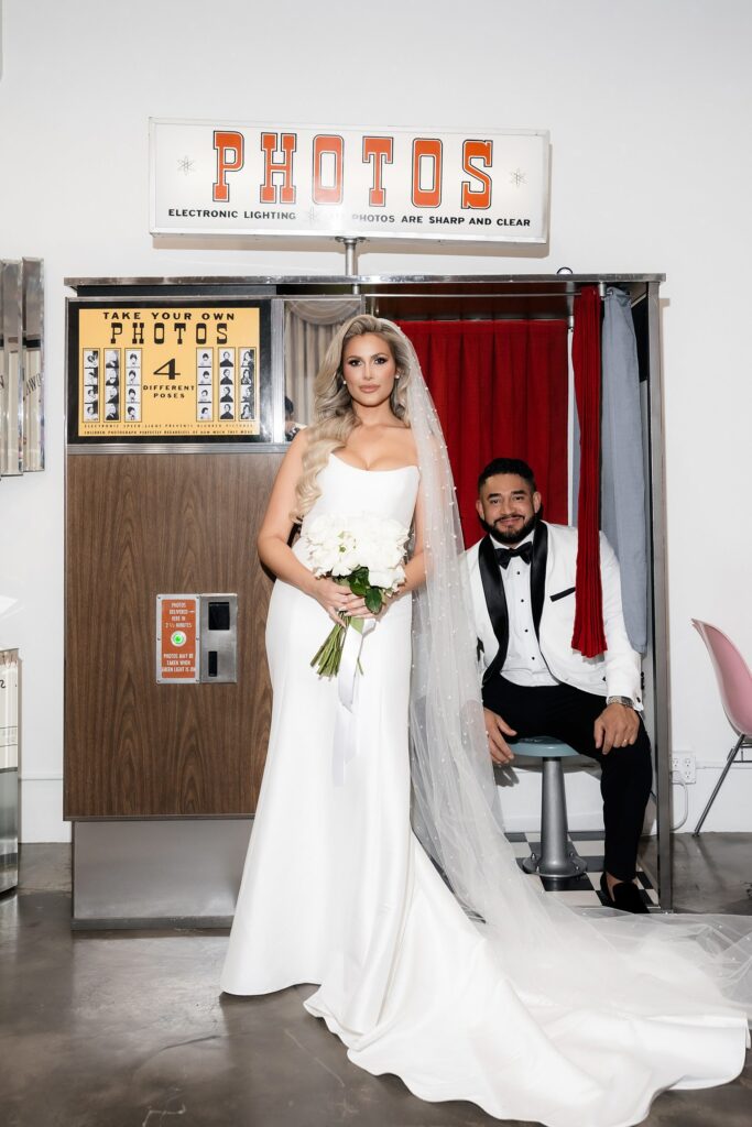 Bride and groom taking pictures in the vintage photo booth at Sure Thing Wedding Chapel