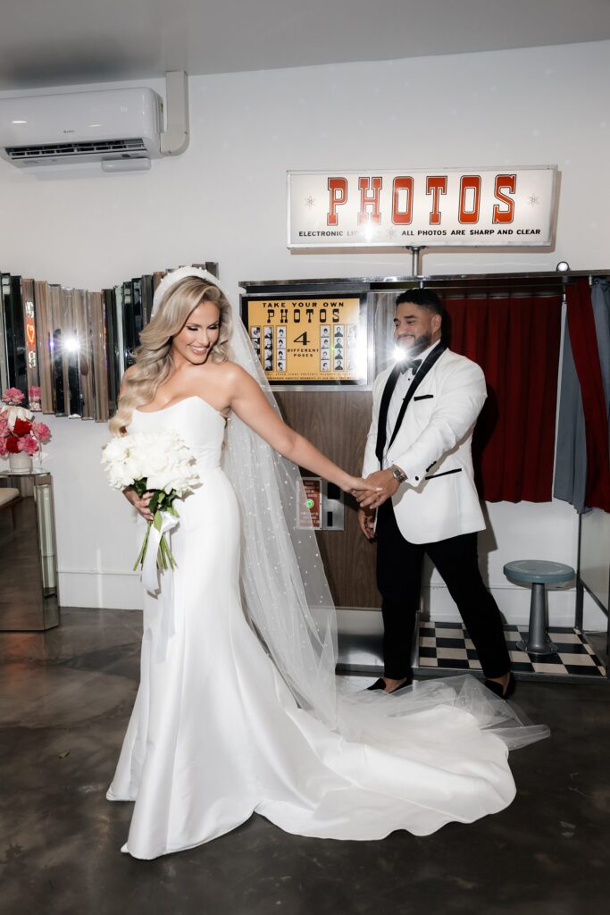 Bride and groom taking pictures in the vintage photo booth at Sure Thing Wedding Chapel