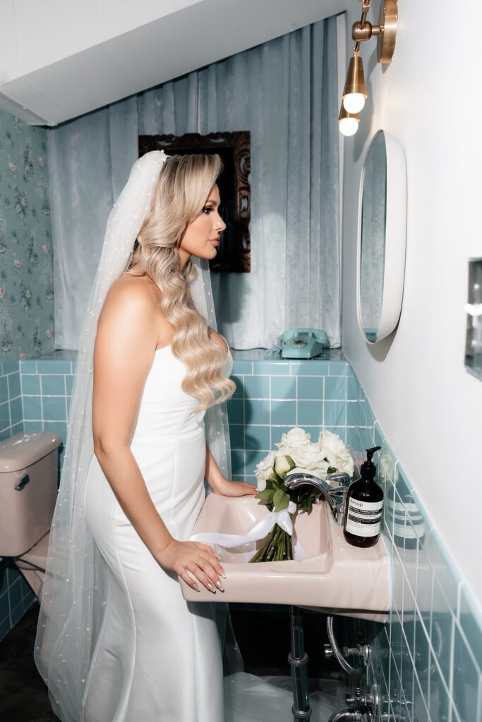 Bride looking at herself in the bathroom mirror at Sure Thing Chapel Las Vegas