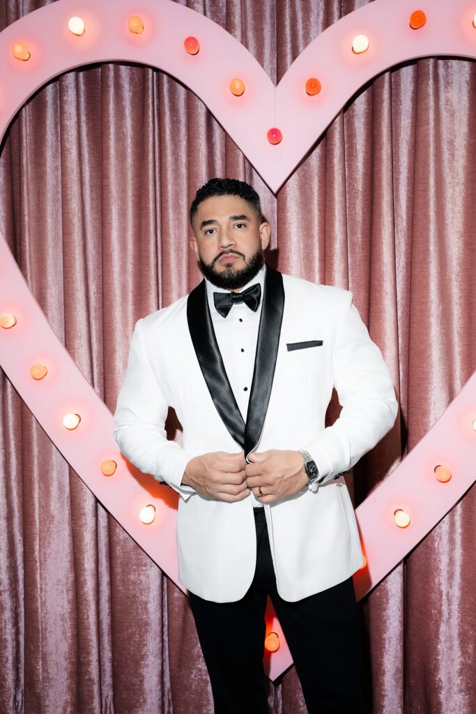 Grooms portraits in front of the pink neon heart at Sure Thing Chapel Las Vegas