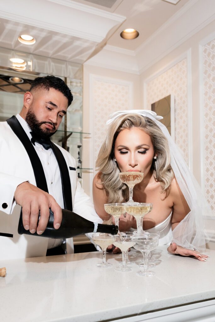 Bride drinking champagne from a champagne tower