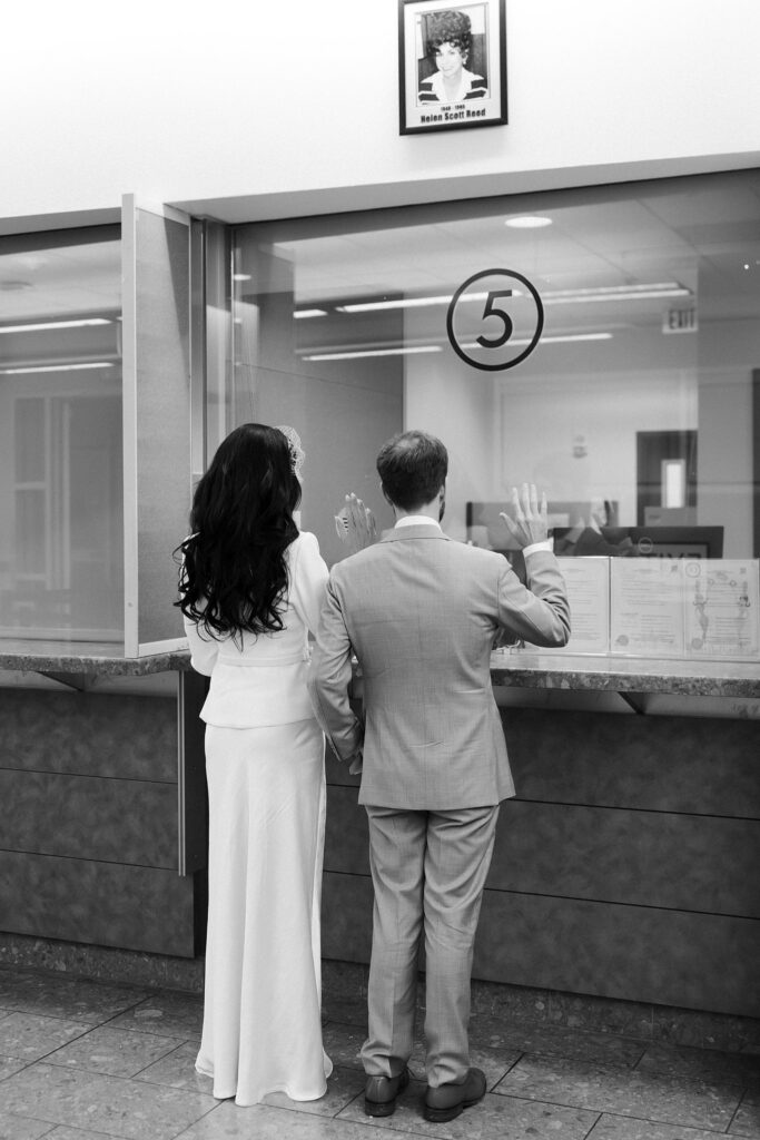 Black and white photo of a couple getting their marriage license at The Clark County Marriage License Bureau.