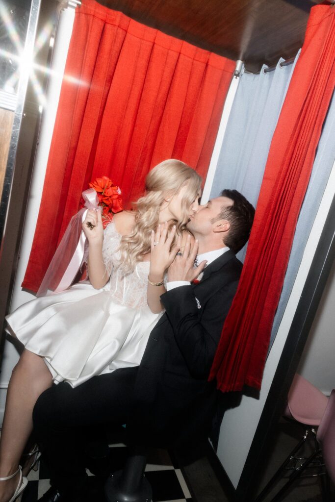 Bride and groom kissing inside the vintage analog photobooth at Sure Thing Chapel in Las Vegas.