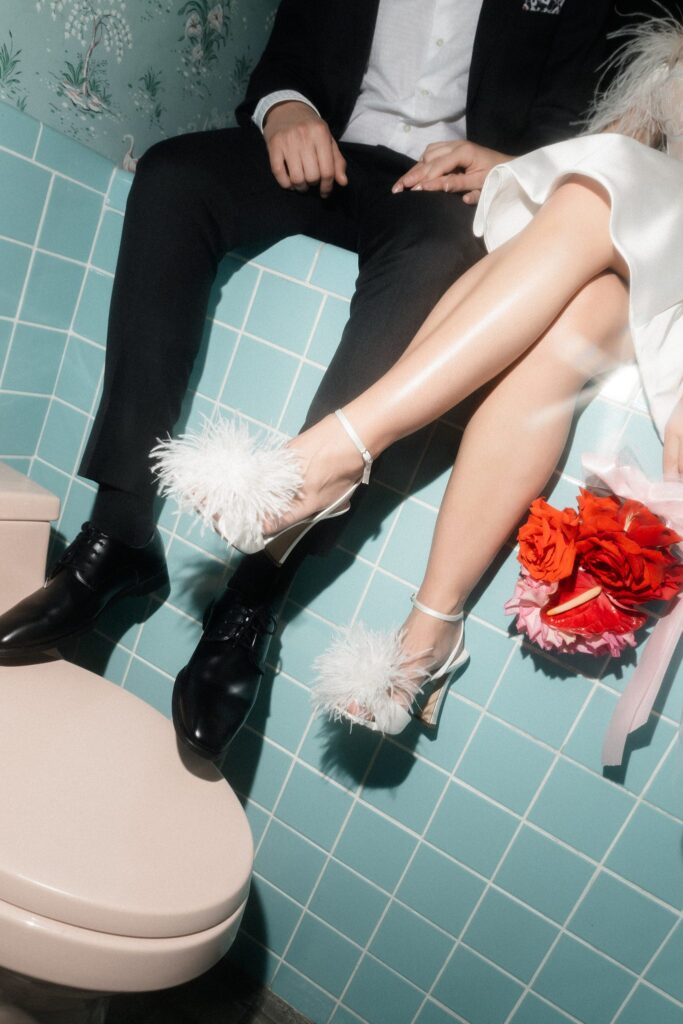 Close up shot of a bride and groom sitting in the baby blue vintage bathroom at Sure Thing Chapel in Las Vegas.